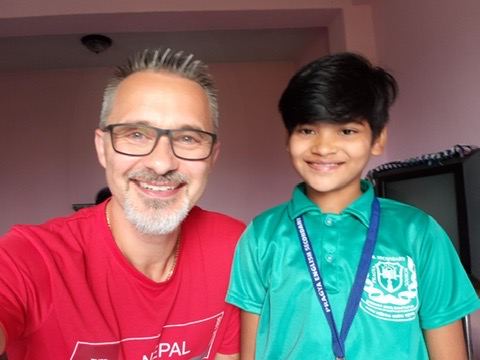 Anu, in her green school uniform, with Pastor Dennis