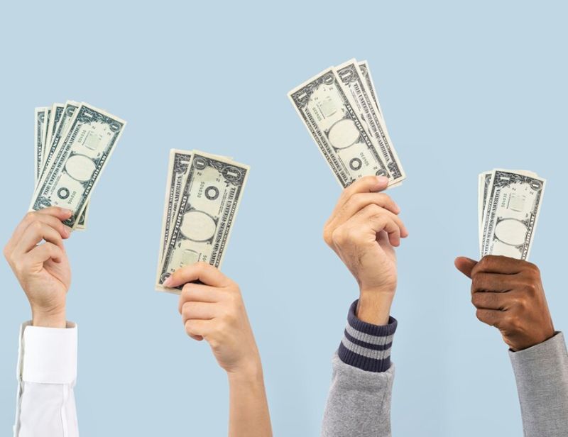 Hands raised holding dollar bills