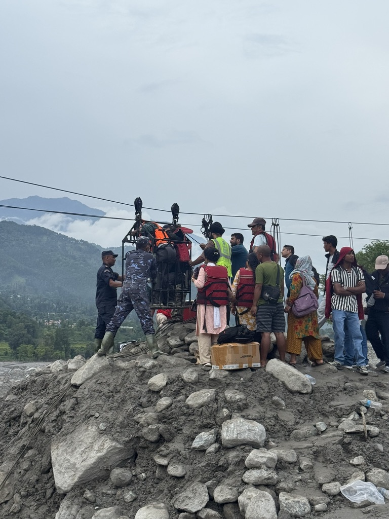 Hearts for Nepal team crossing the river by cable to deliver supplies