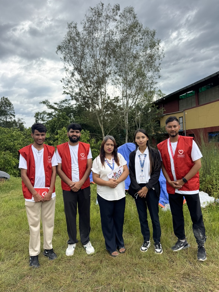Hearts for Nepal staff standing with local officials at a relief site