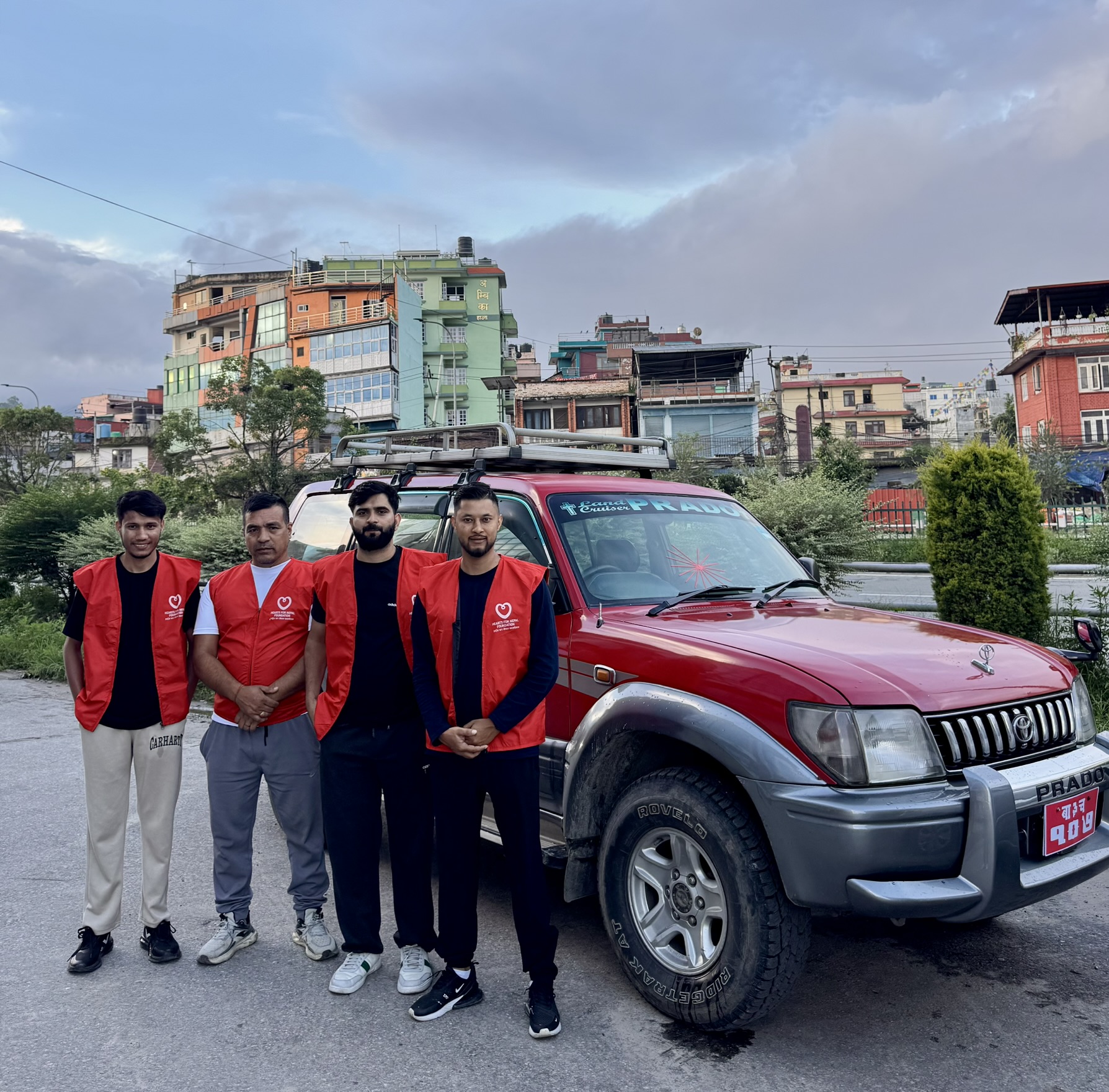 Hearts for Nepal relief team in red vests beside their vehicle before leaving for the flood zone